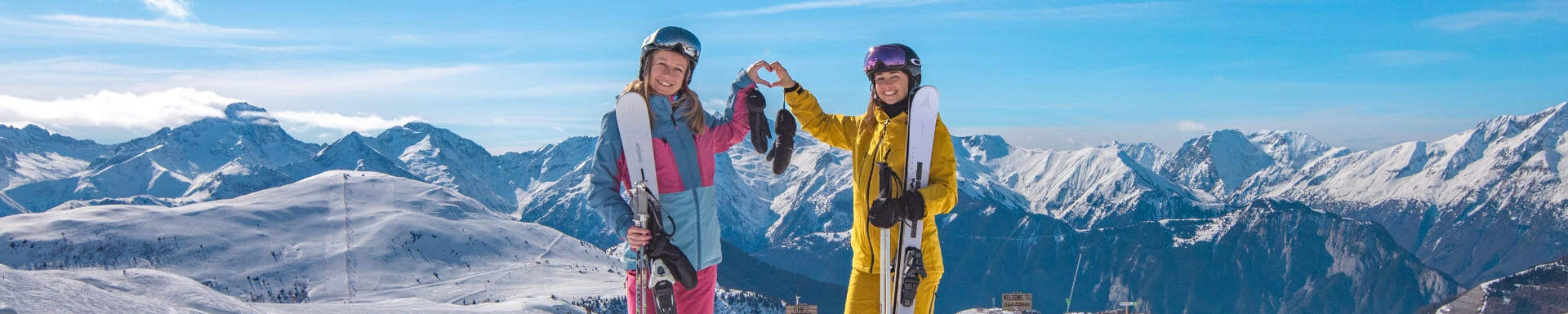 Deux enfants au ski formant un coeur avec leurs mains