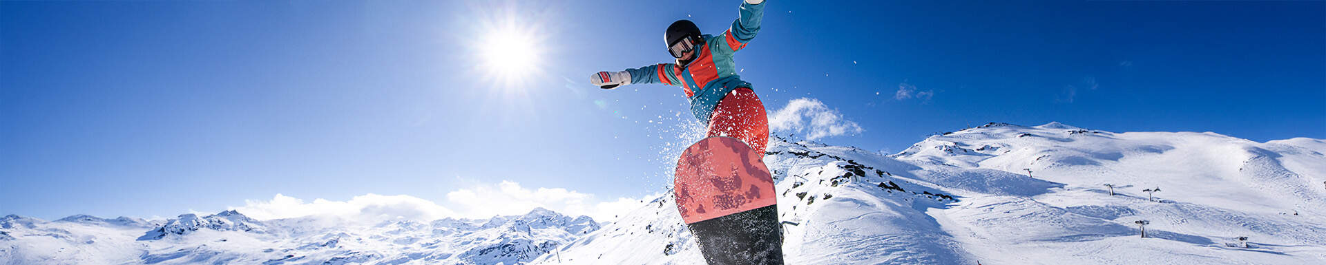 Un snowboarder sur les pistes ensoleillées