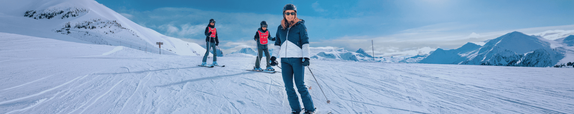 Une femme et deux enfants sur les pistes de ski