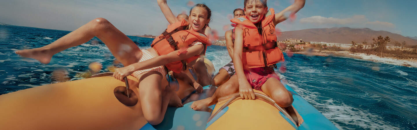 header 2 enfants sur une banane en pleine mer