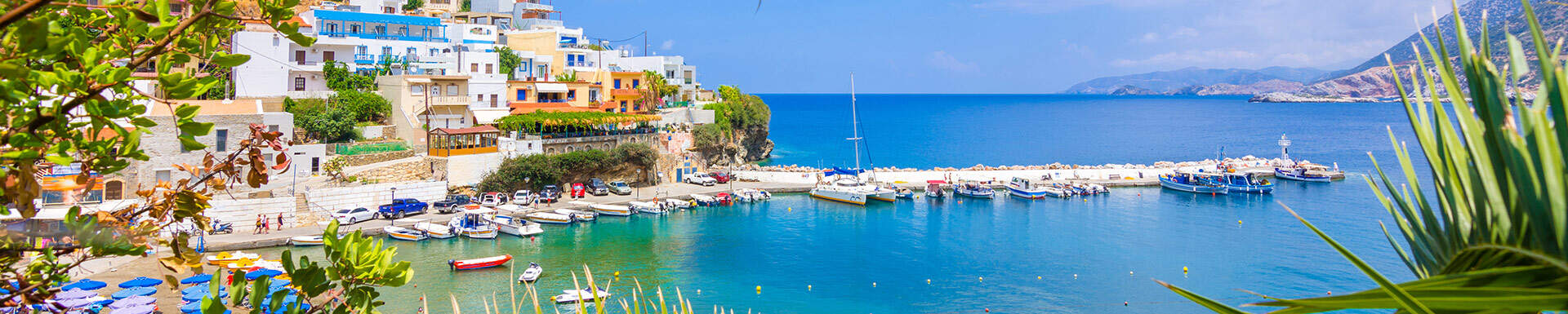 Paysage avec maisons sur falaise donnant sur mer et ses bateaux