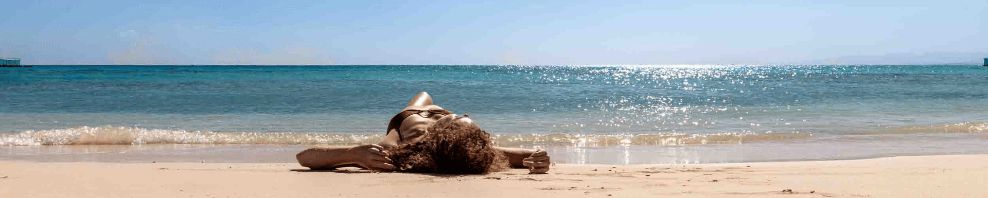 Femme se prélassant sur sable chaud