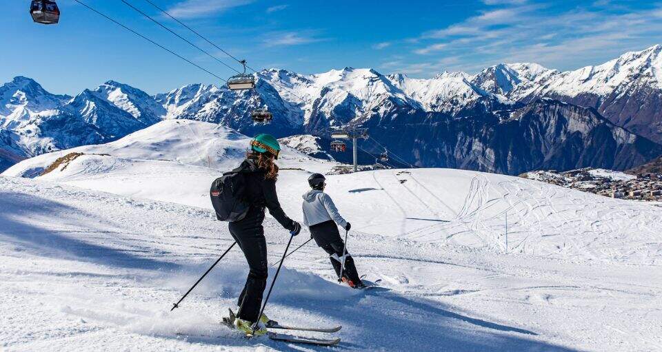Deux skieurs dévalant les pistes de l'Alpe d'Huez