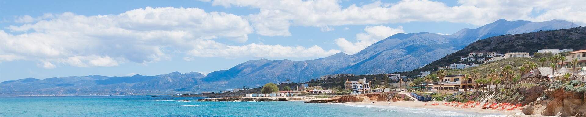 Vue aérienne de la baie de Chersonnissos, en Grèce, de ses maisons et des montagnes en arrière-plan