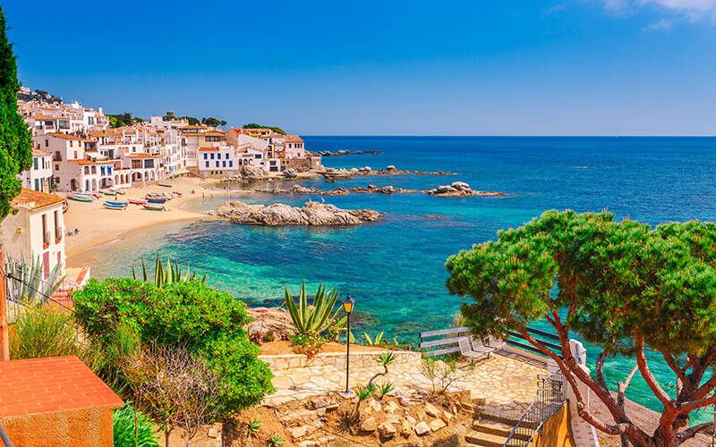 Vue d'ensemble plage aux eaux cristallines entourée d'habitations et de verdure