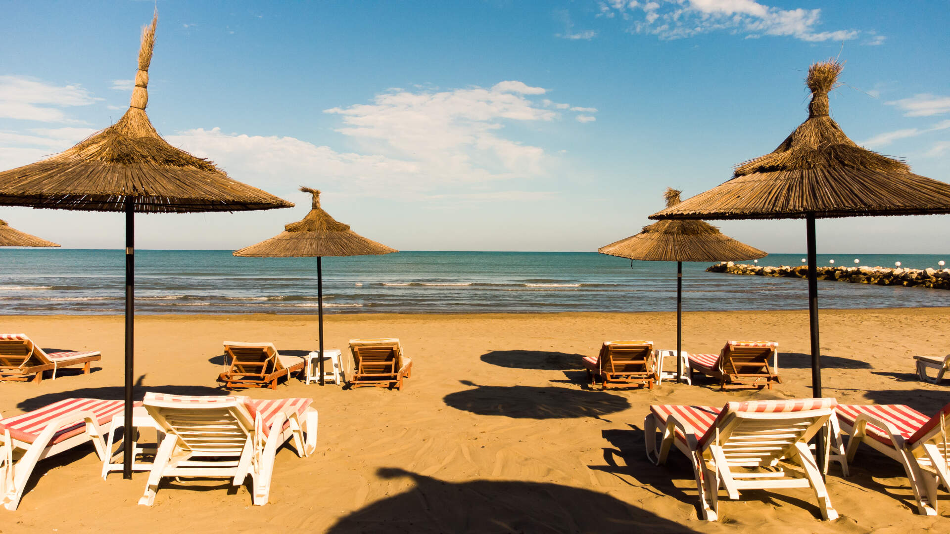 Une plage de sable fin en Tunisie dotée de parasols et de chaises longues