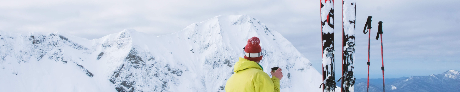 Un skieur assis face aux montagnes