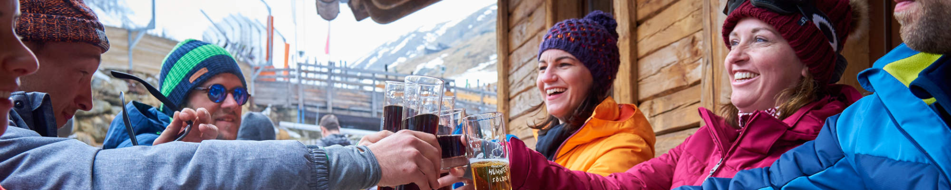 Un groupe d'amis trinquant ensemble sur une terrasse au ski