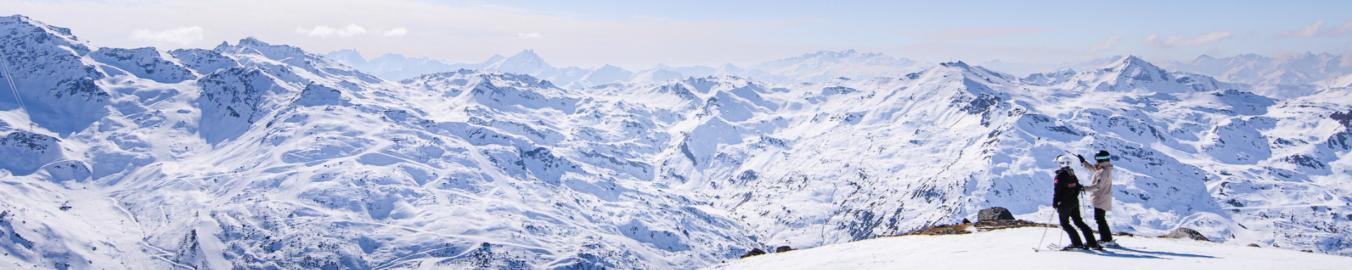 Deux skieurs admirant la vue sur les montagnes enneigées