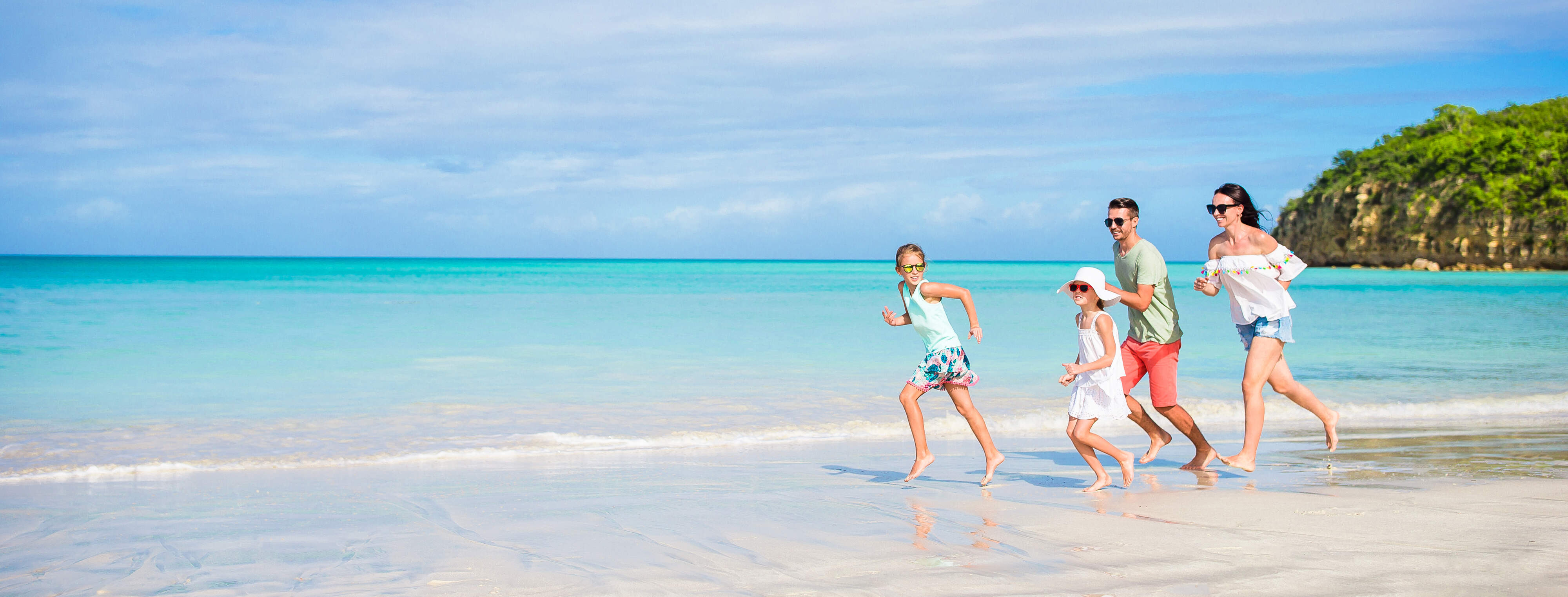 Famille qui court en bord de plage aux eaux claires