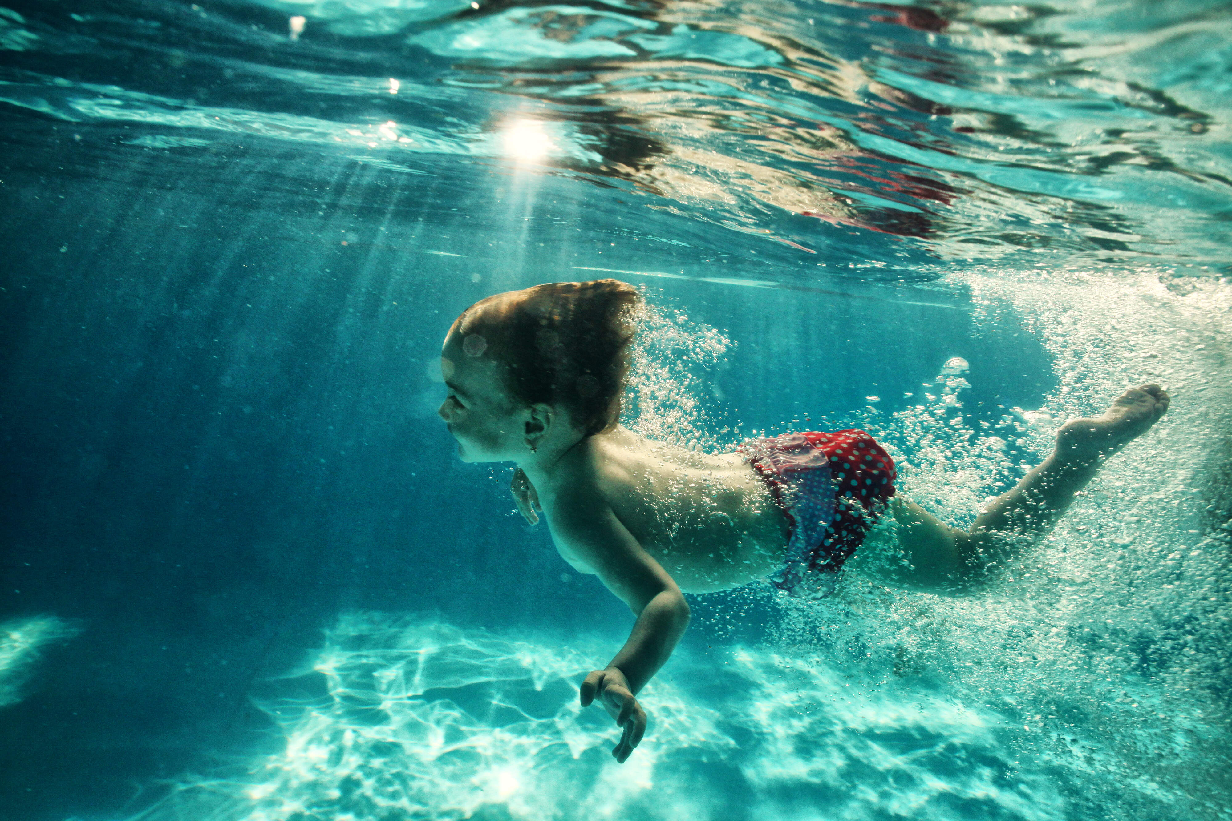 Un enfant nageant sous l'eau dans une piscine